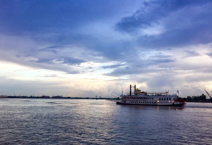 Ferry boat on the Mississippi River in New Orleans with a cloudy blueish sky and fading sunset